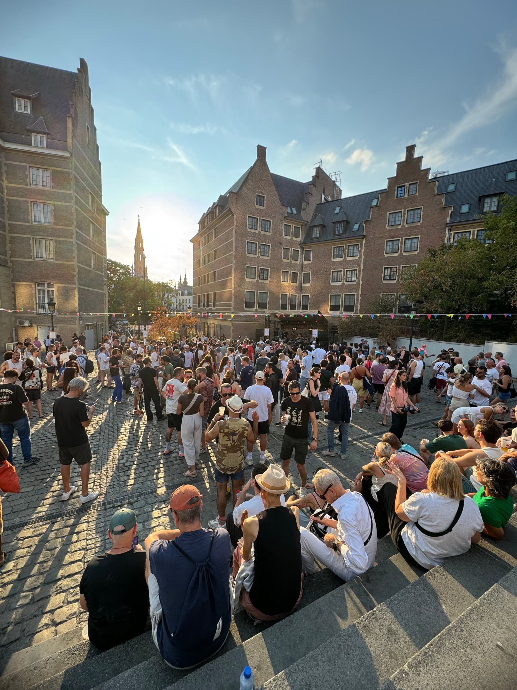 The crowd spreading across Place d'Espagne in low afternoon sun, historic facades behind.